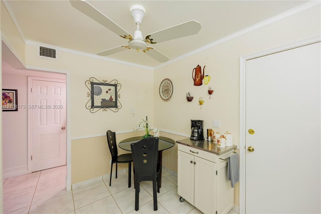 White tile flooring, dual-tone wall treatment with chair rail, and ceiling fan with integrated lighting