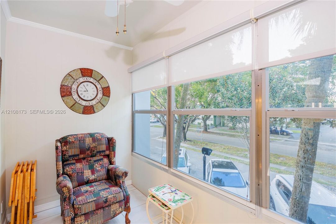 Sunroom featuring expansive floor-to-ceiling windows with integrated roller shades and a ceiling-mounted fan