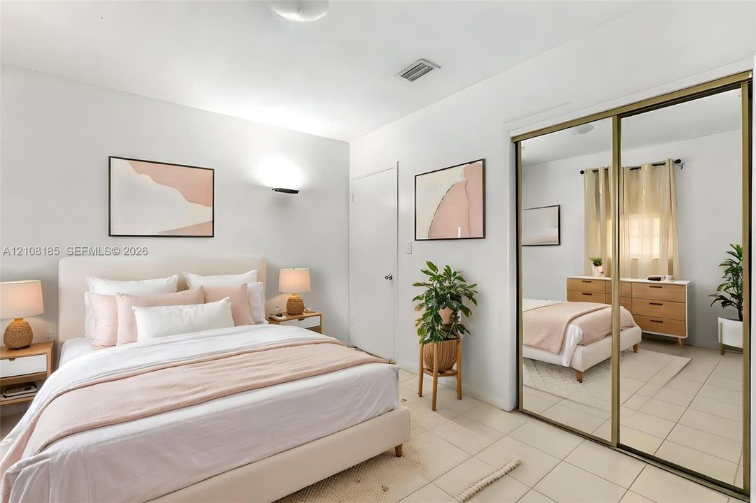 Neutral-toned interior featuring tiled flooring and dual-panel sliding mirror closet doors