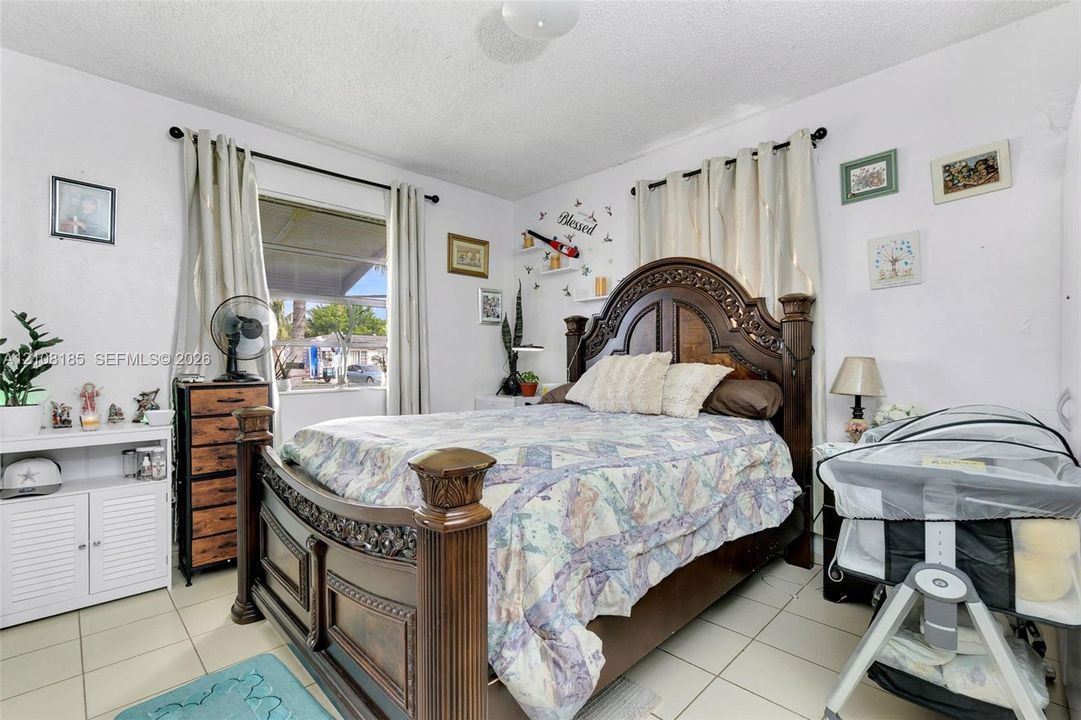 Room with ceramic tile flooring, dual windows with wall-mounted curtain rods, and a ceiling-mounted light fixture