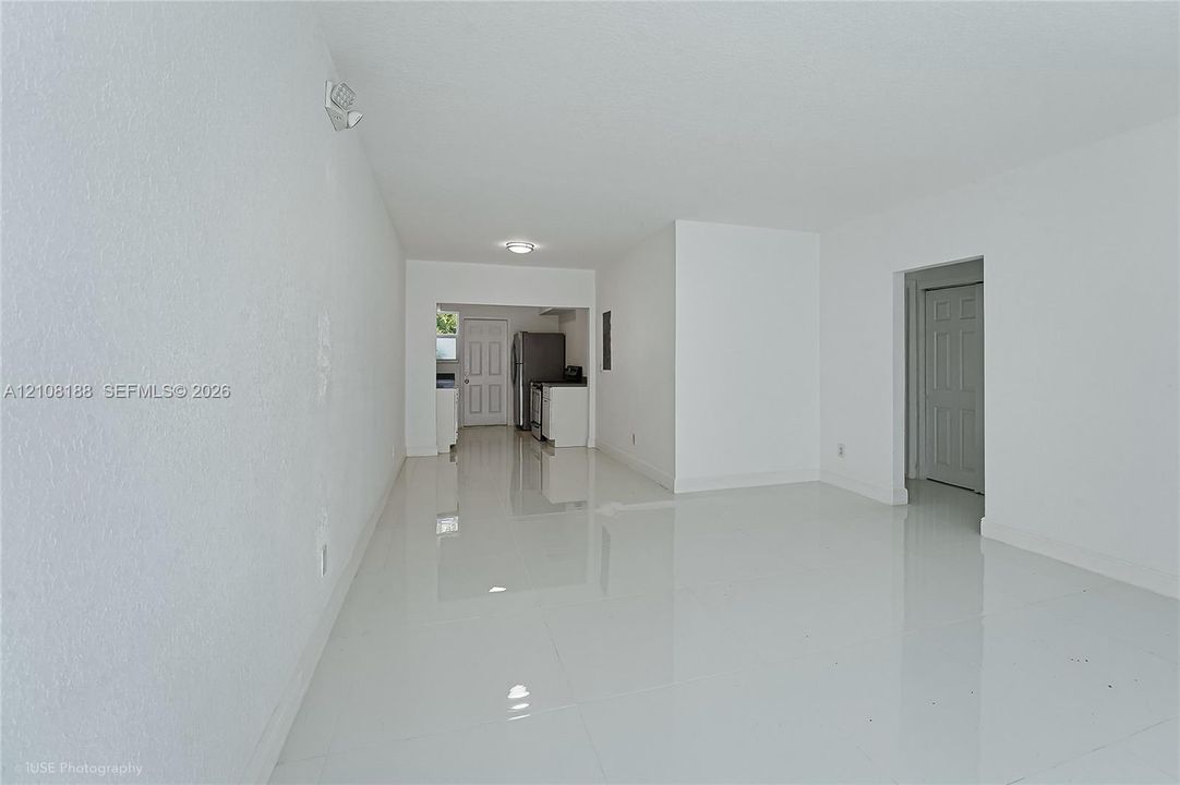 Open interior featuring polished tile flooring, smooth-finish walls, recessed ceiling lighting, and six-panel interior doors