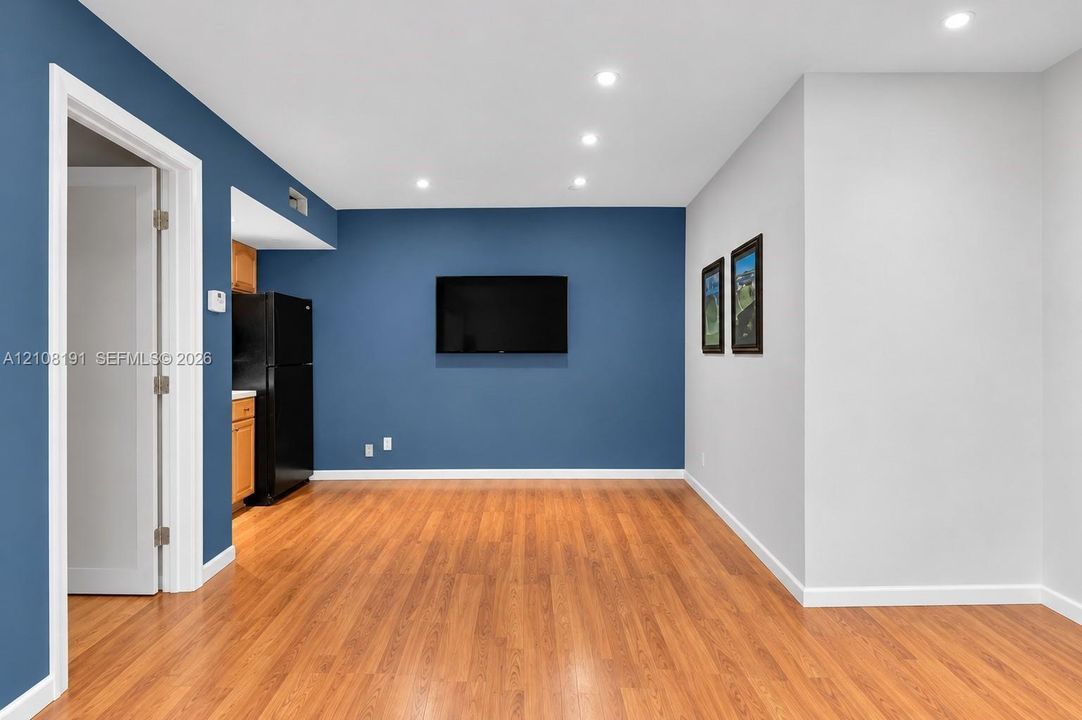 Open-concept interior featuring wood-finish flooring, recessed lighting, and painted accent walls