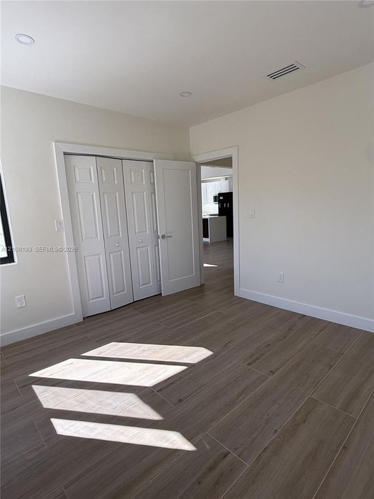 Interior space featuring wood-finish tile flooring, recessed lighting, and a multi-panel bi-fold closet door