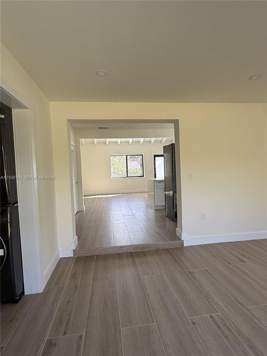 Interior space featuring wood-finish tile flooring, recessed lighting, and a multi-level floor plan with an exposed beam ceiling