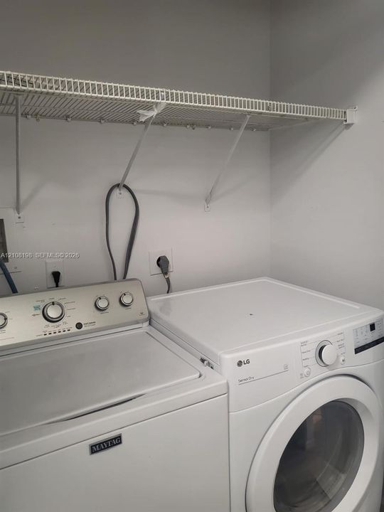 Laundry area featuring a wire-grid wall-mounted shelving unit