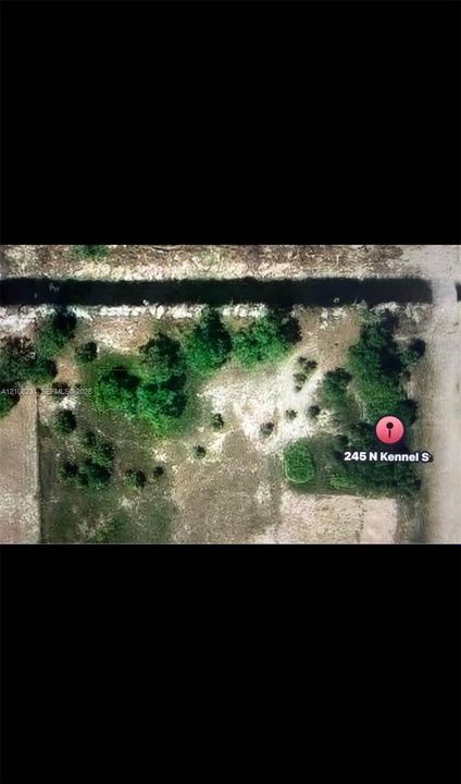 Aerial view of the parcel featuring mature trees, native vegetation, and a natural waterway boundary