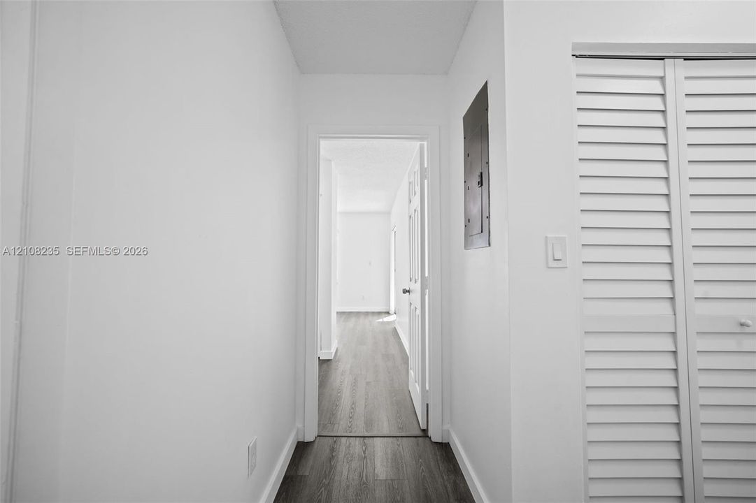 Wood-finish flooring, white walls, and bi-fold louvered closet doors