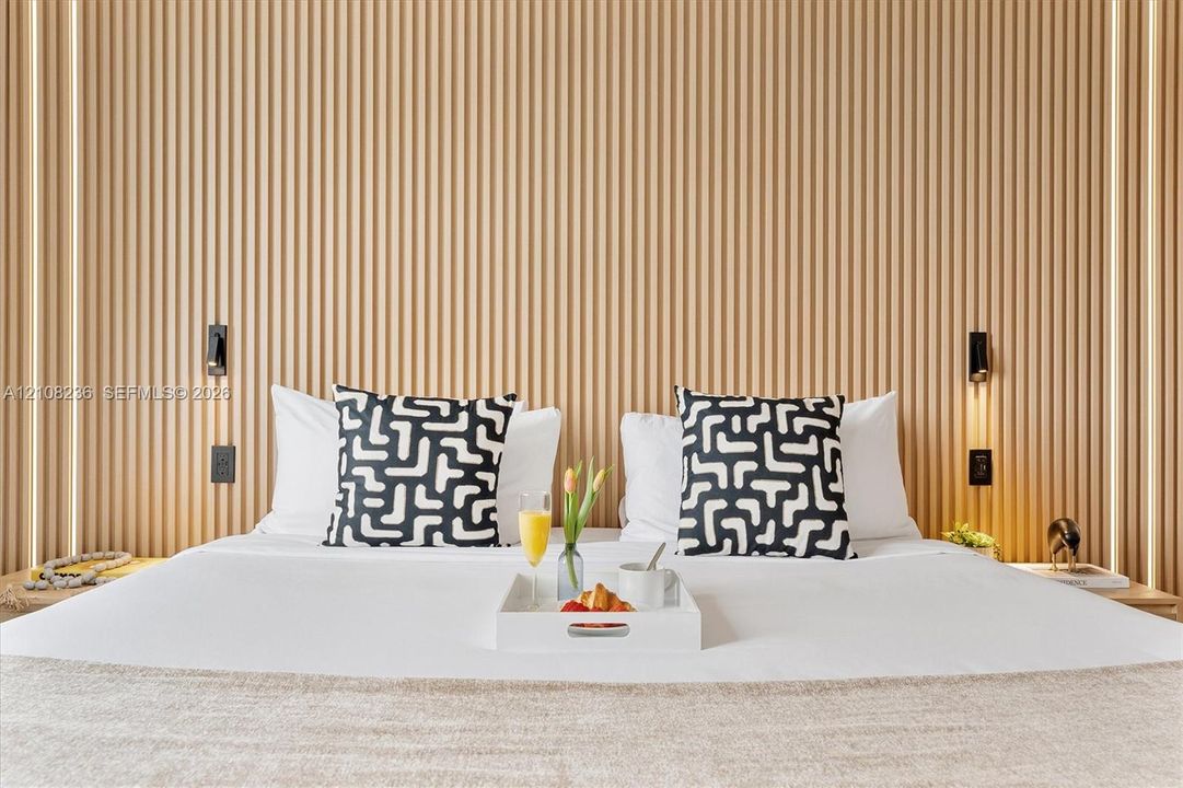 Vertical wood slat accent wall featuring integrated recessed LED lighting strips and wall-mounted reading lights