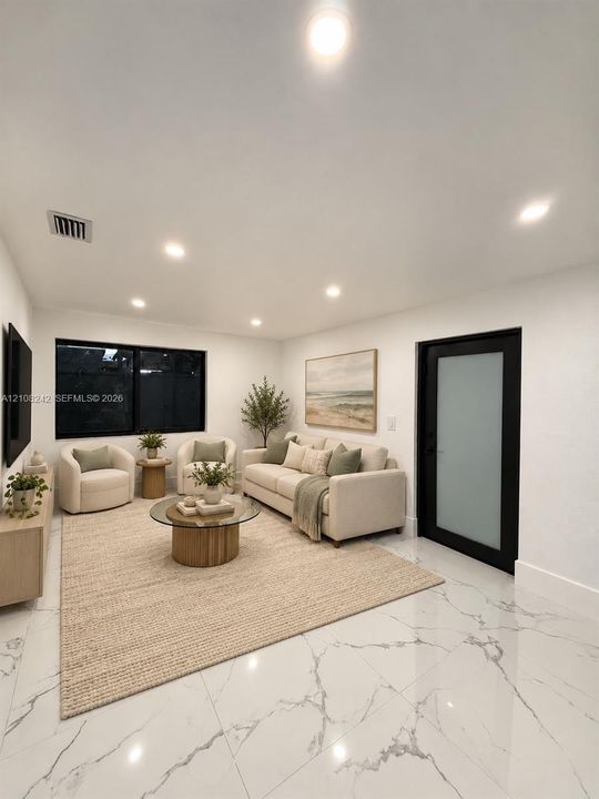Large-format tile flooring with marble-style veining, recessed lighting, and a modern door featuring a frosted glass panel and black frame