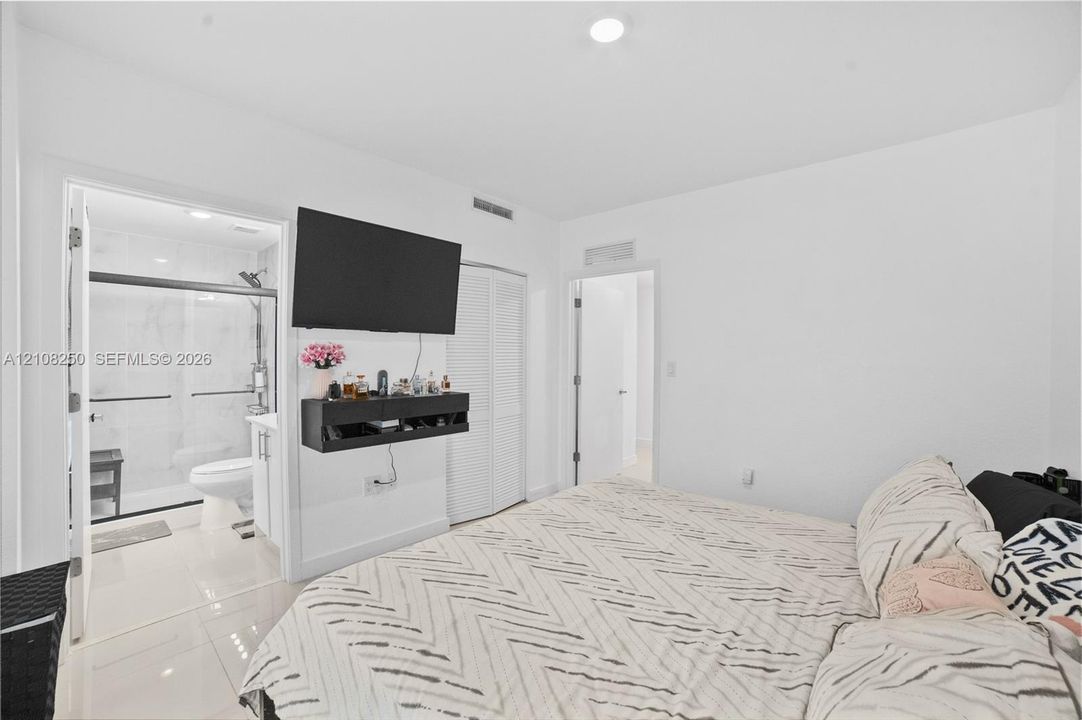 Room featuring large-format tile flooring, white louvered-door closet, and recessed ceiling lighting
