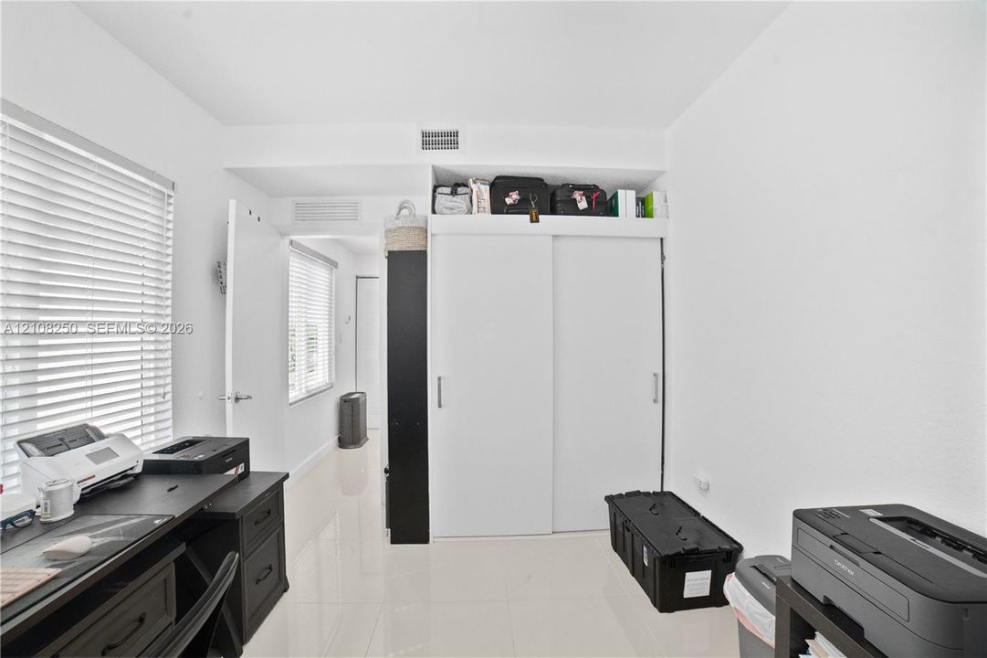 Interior space featuring tile flooring, white sliding-door closet, and window blinds