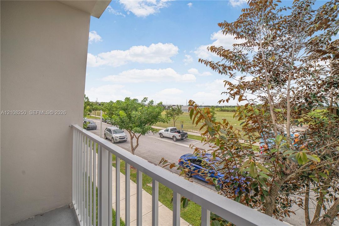Covered balcony featuring white vertical balusters and concrete flooring
