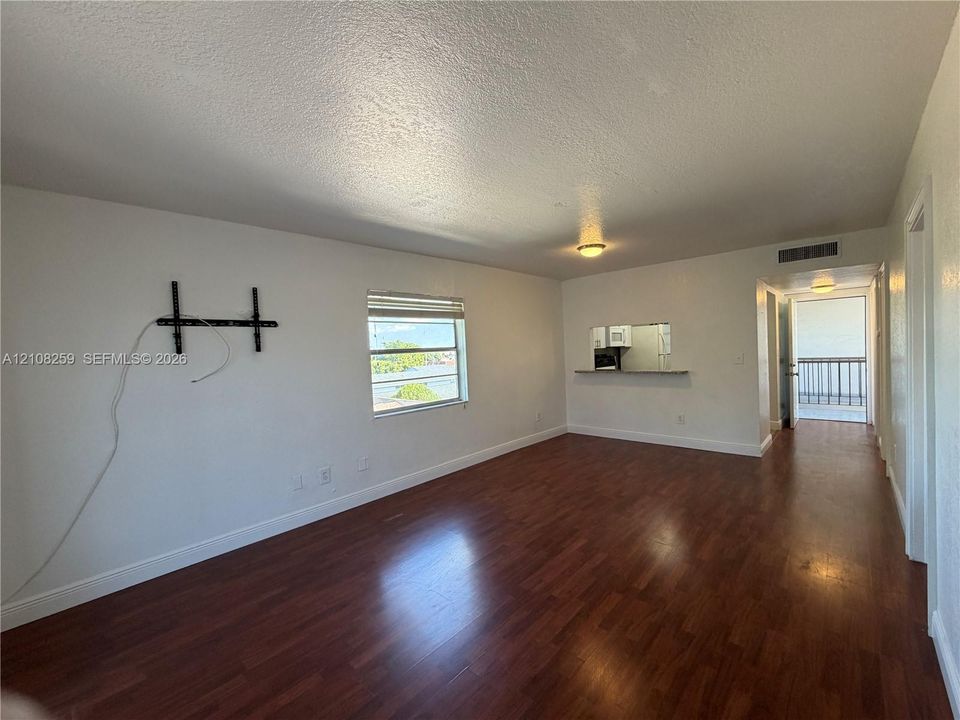 Interior space featuring wood-finish flooring, a pass-through window with a built-in counter, and neutral wall tones