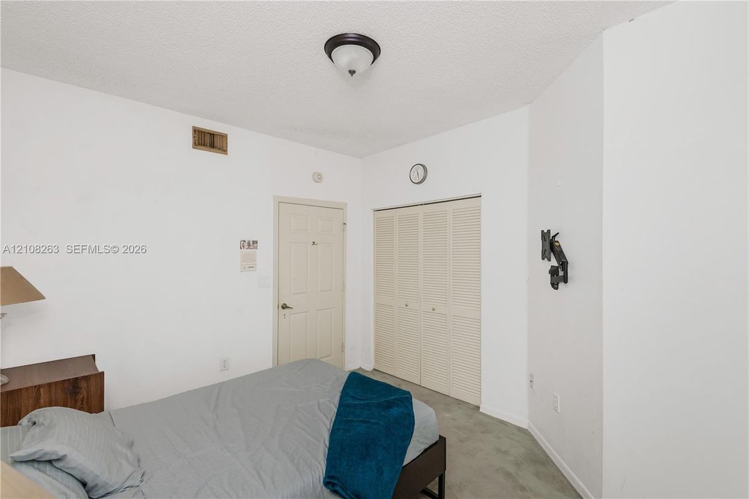 Interior room featuring a multi-panel door, bi-fold closet doors, and a flush-mount ceiling light fixture