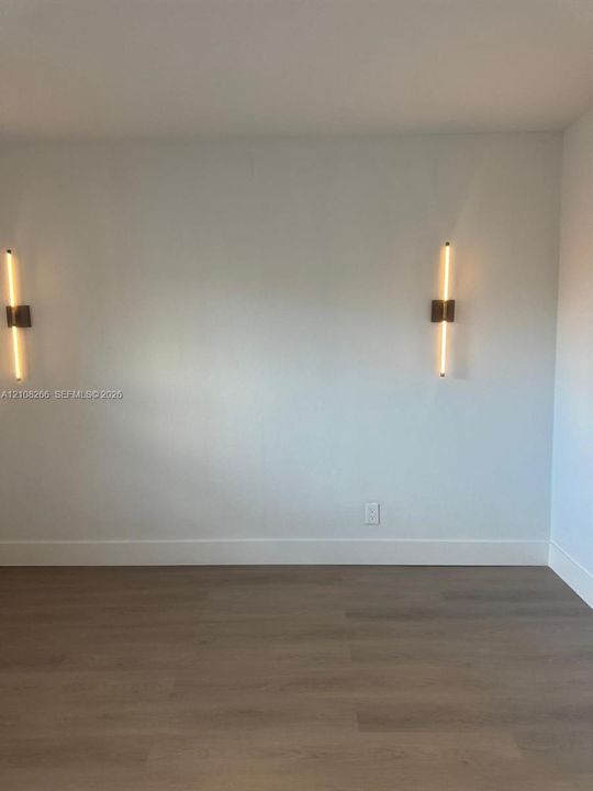 Wood-finish flooring paired with two contemporary linear wall-mounted light fixtures
