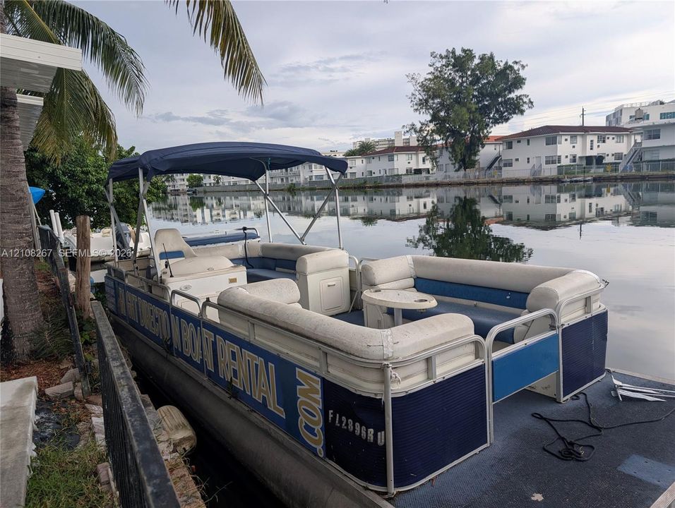 Waterfront property featuring a canal-side bulkhead and mature palm tree