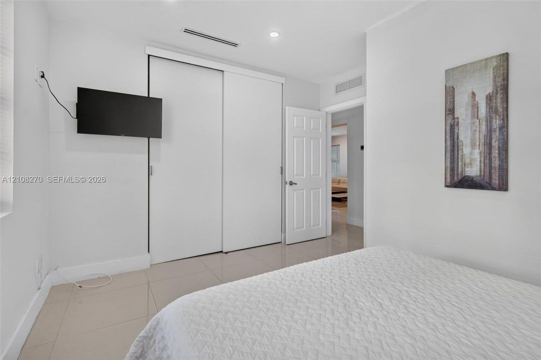 Neutral-toned ceramic tile flooring, sliding-door closet, recessed lighting, and six-panel interior door