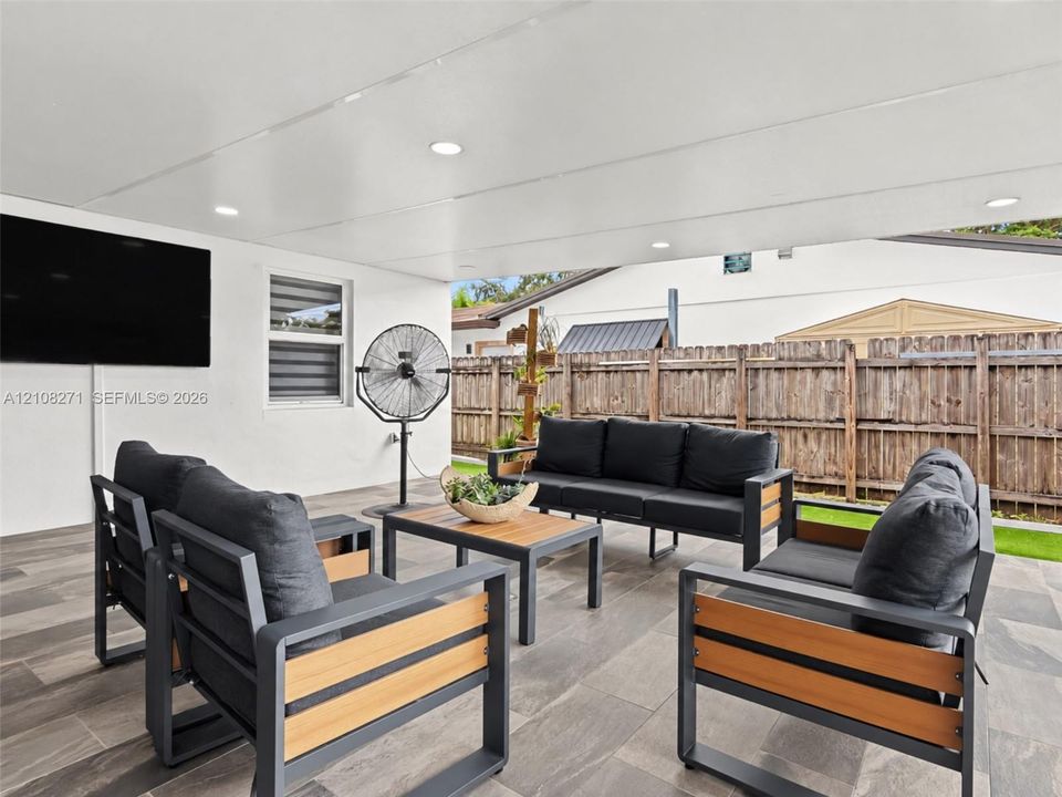 Covered patio featuring large-format porcelain tile flooring, recessed ceiling lighting, and a white smooth-finish ceiling