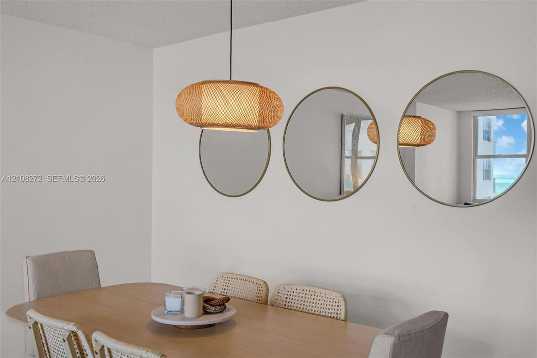 Woven rattan pendant light fixture and three circular wall-mounted mirrors with metallic frames