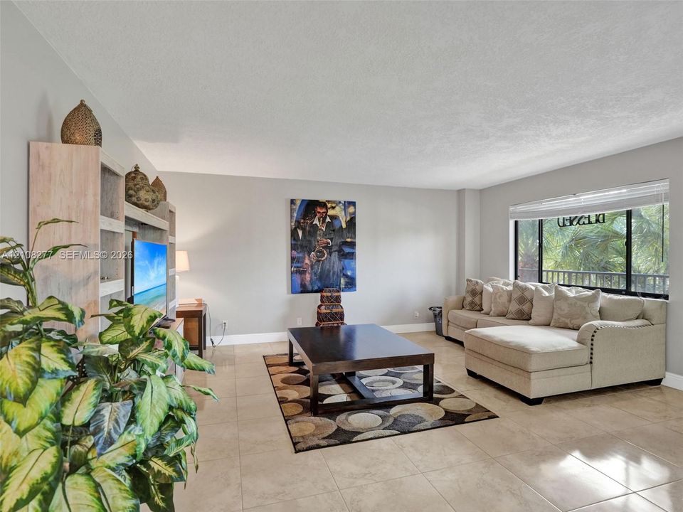 Neutral-toned tile flooring, built-in floor-to-ceiling shelving, and expansive window with integrated blind