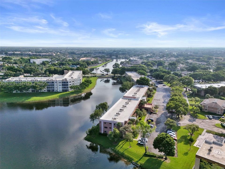 Aerial perspective featuring waterfront residential buildings, mature trees, and landscaped green space