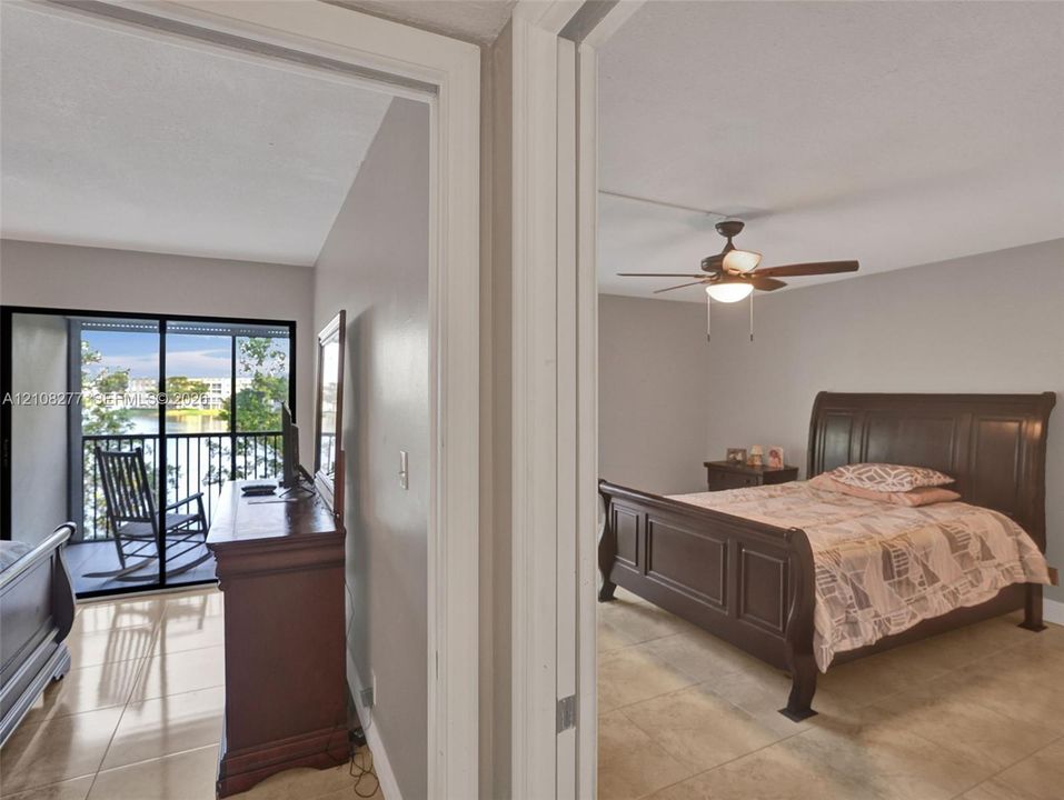 Tile flooring throughout, ceiling fan with light fixture, and sliding glass door opening to a screened balcony