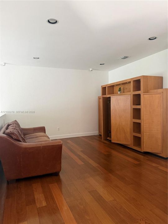 Custom built-in wood cabinetry, wood-finish flooring, and recessed ceiling lighting