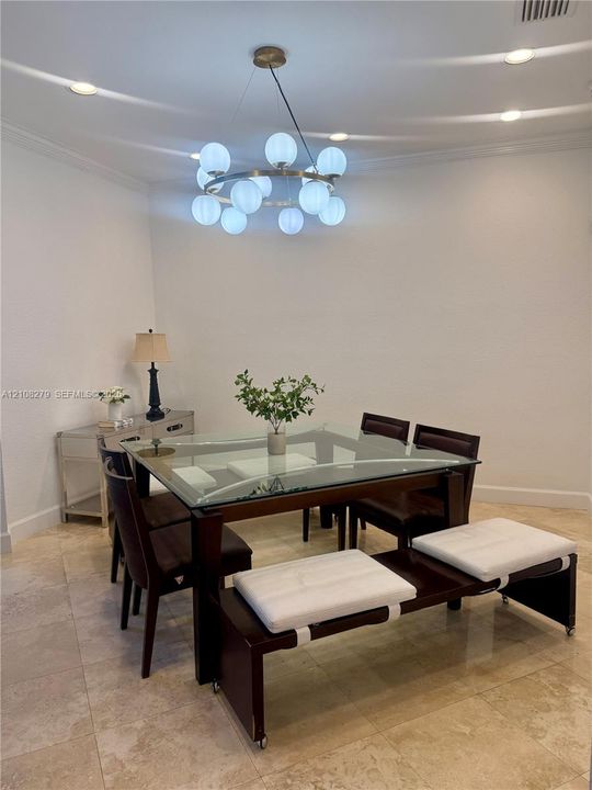 Circular multi-light chandelier, recessed lighting, and stone flooring