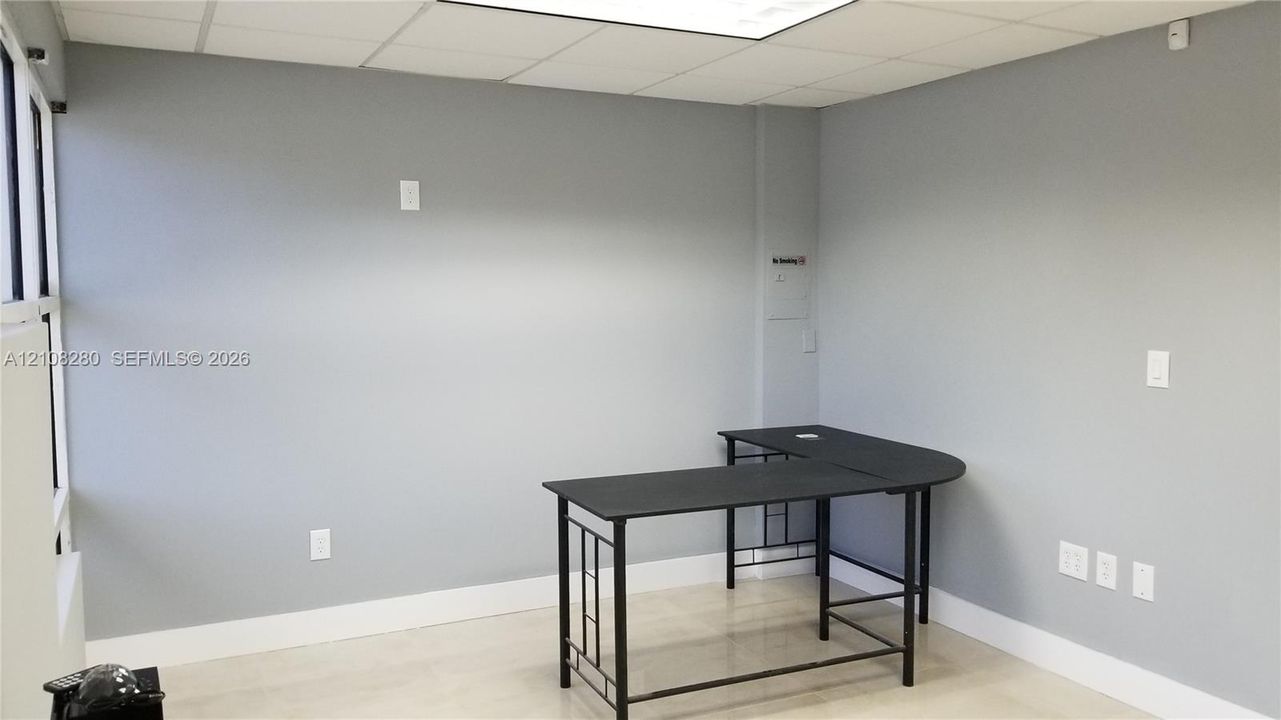 Neutral gray walls, polished neutral-toned tile flooring, and a large-format window system with integrated metal framing