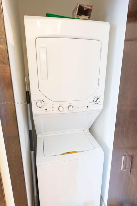White stacked laundry center with top-load washer and front-load dryer configuration