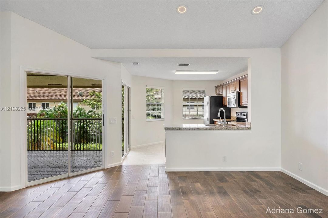 Kitchen featuring a stone-surface breakfast bar, wood-finish flooring, sliding glass doors, and recessed lighting