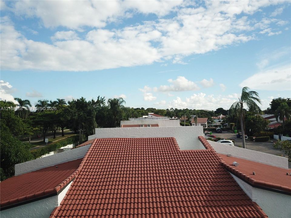Terracotta-style tile roofing contrasted by white textured exterior walls