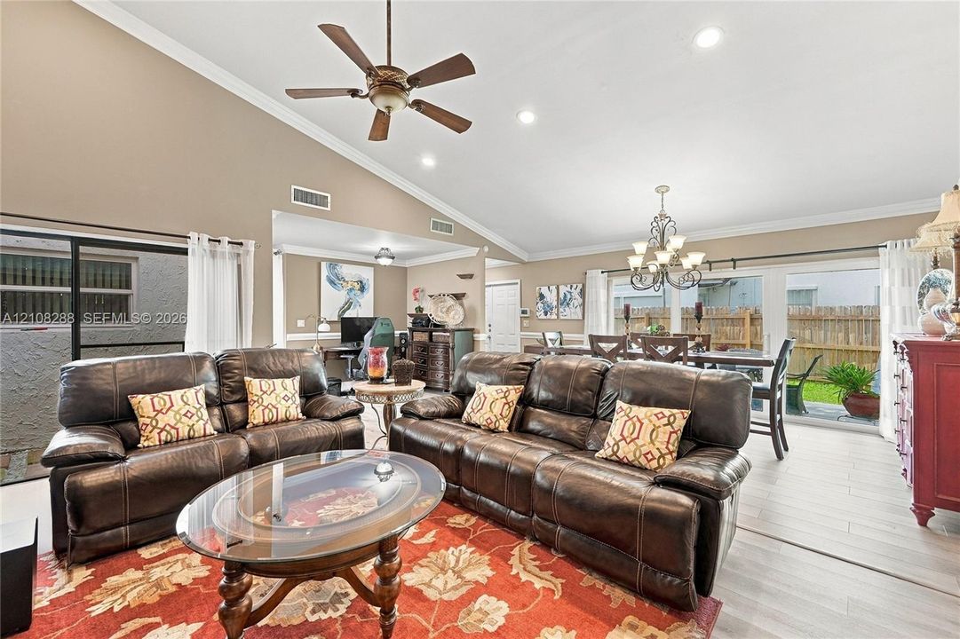 Vaulted ceilings, recessed lighting, wood-finish flooring, ceiling fan, and sliding glass doors