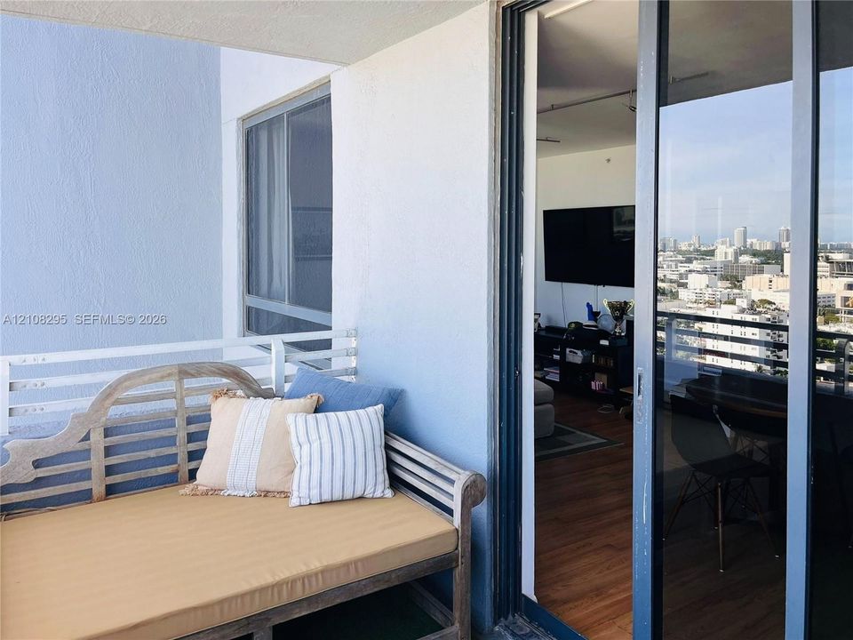 Private balcony featuring a white metal railing and sliding glass door entrance