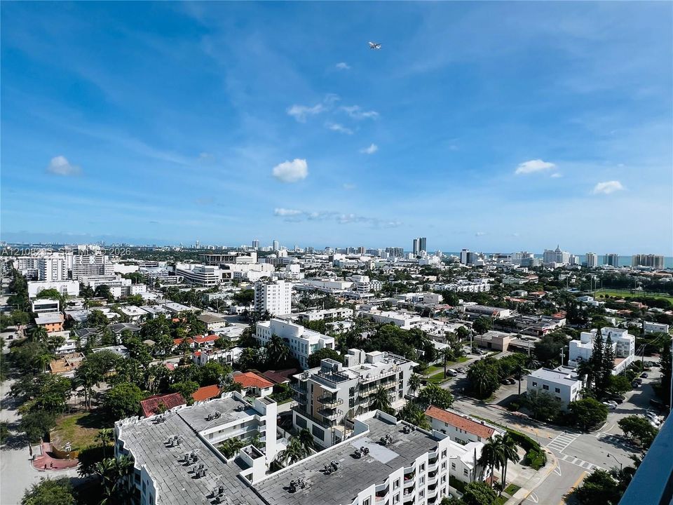 Elevated aerial perspective featuring a panoramic urban landscape with coastal horizon
