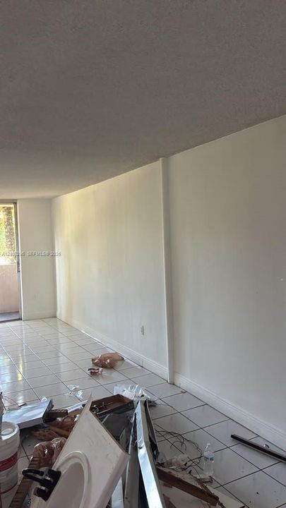 Interior space featuring white-toned tile flooring and an exterior glass door