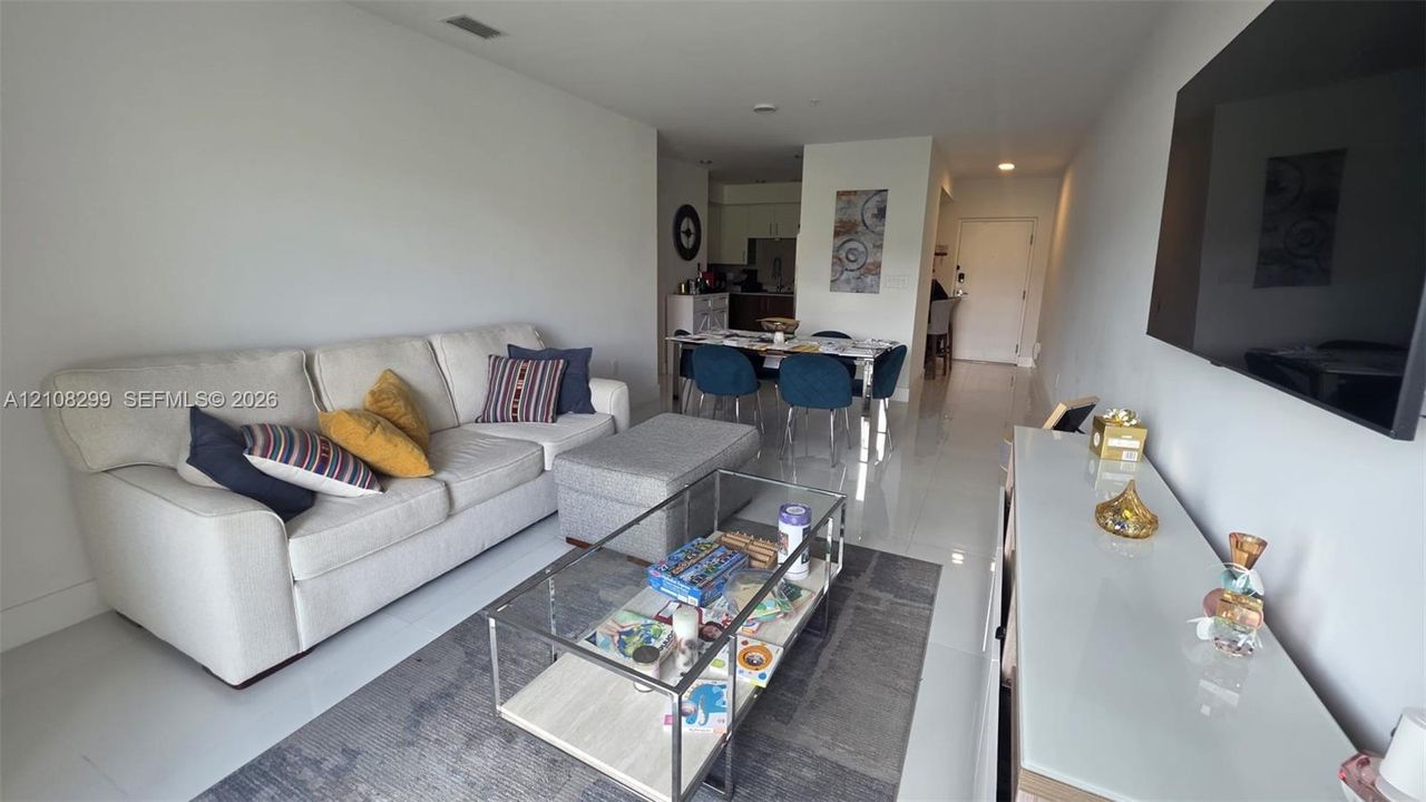 Open-concept living space featuring high-gloss tile flooring, smooth-finish ceilings, and recessed lighting