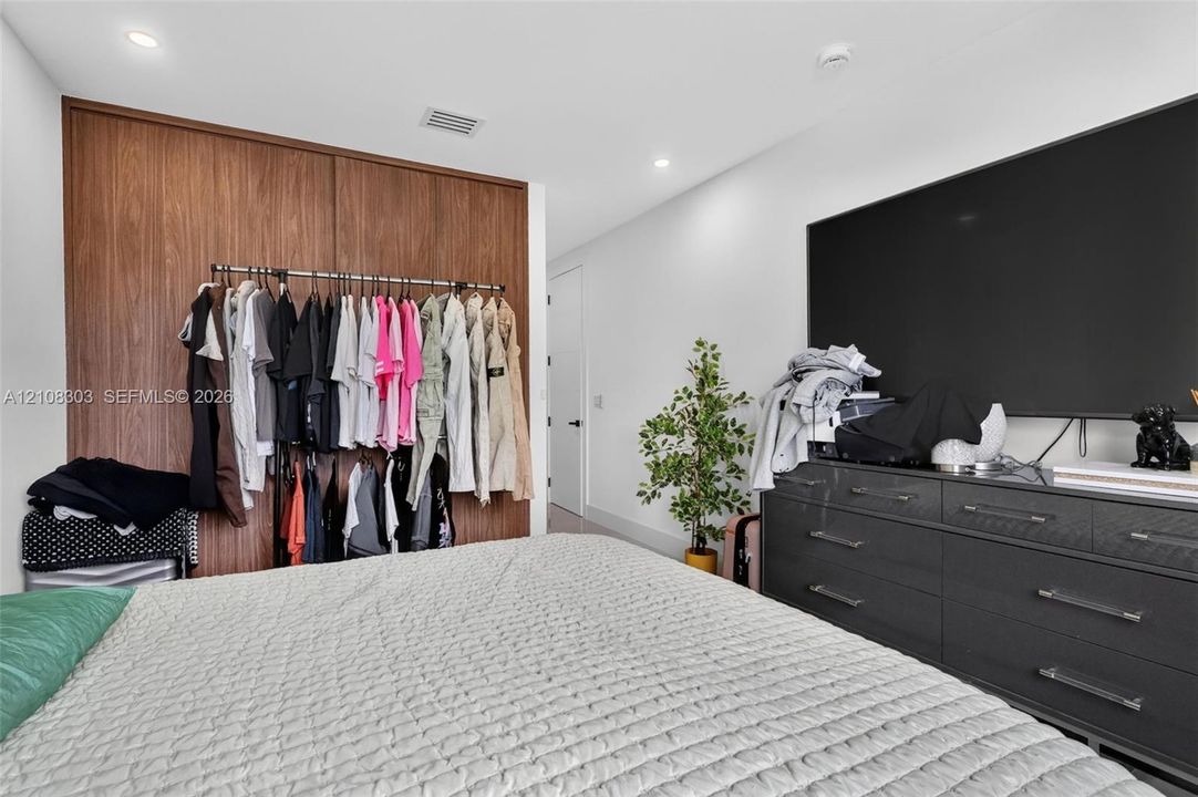 Floor-to-ceiling wood-finish built-in cabinetry featuring sliding doors and recessed ceiling lighting