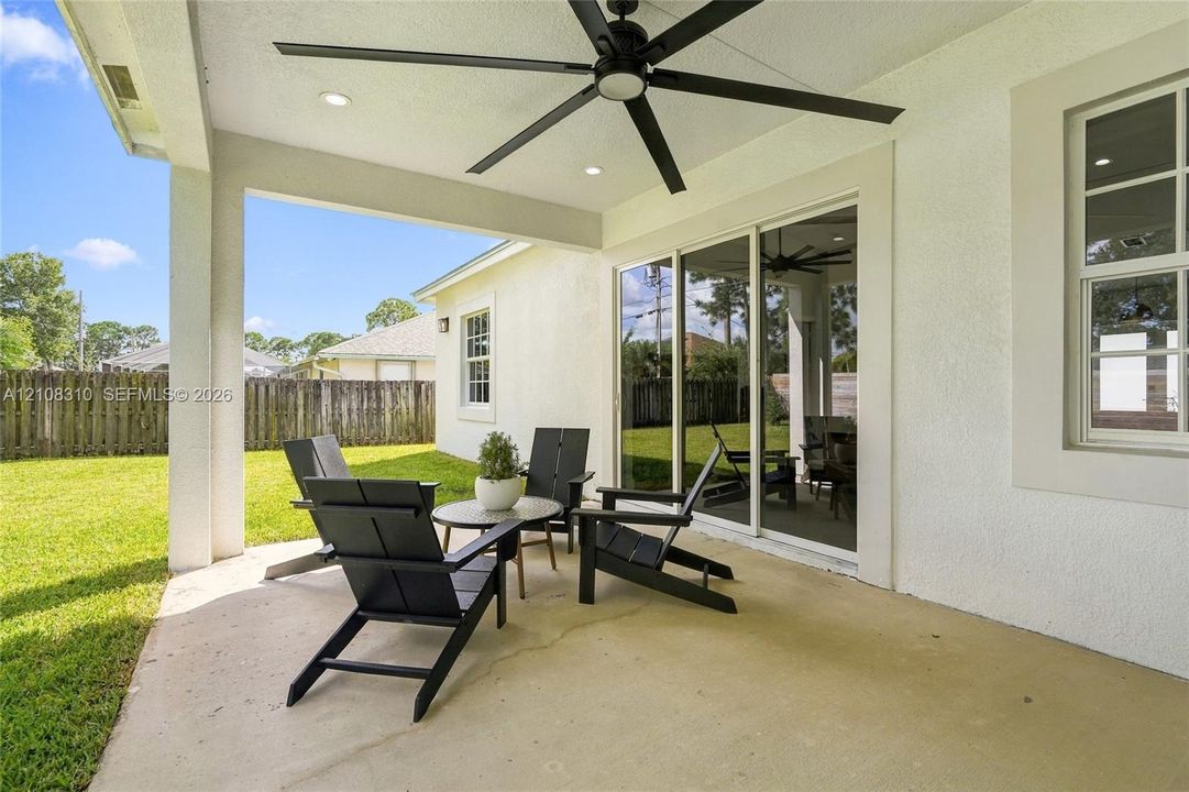 Covered patio featuring concrete flooring, a large ceiling fan, recessed lighting, and sliding glass doors