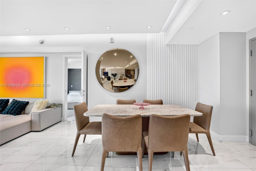 Polished stone-finish flooring, vertical fluted wall paneling, and recessed ceiling lighting