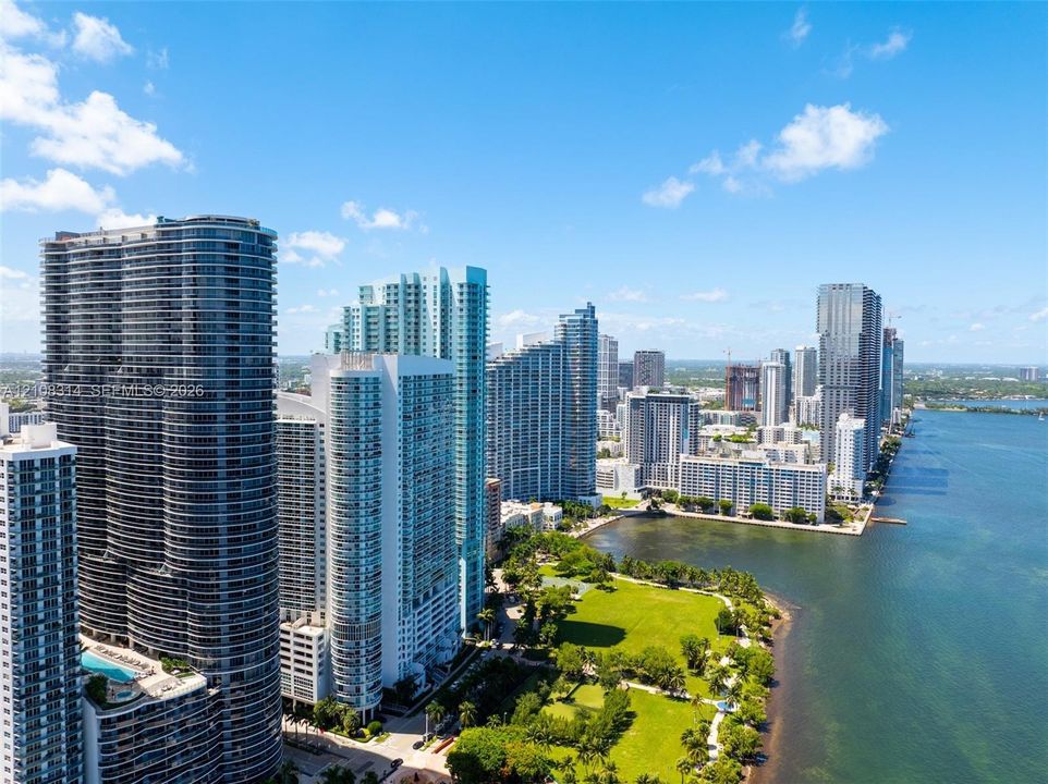 High-rise coastal cityscape featuring waterfront access, expansive green space, and architectural tower structures