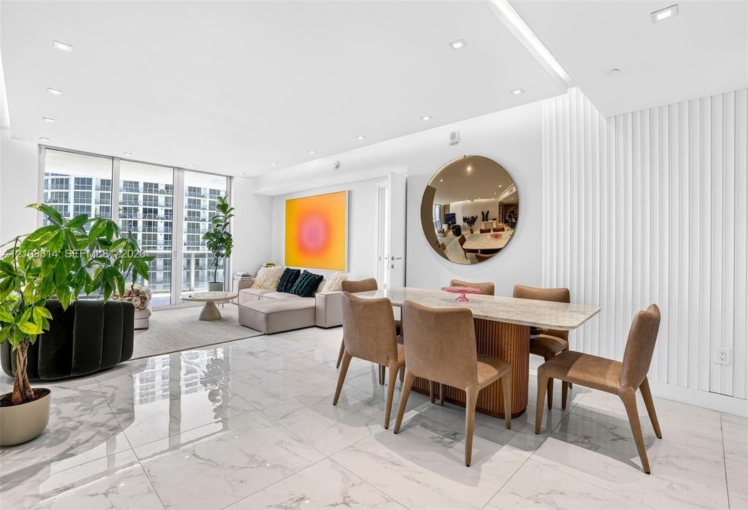Large-format tile flooring, vertical wall paneling, recessed lighting, and floor-to-ceiling glass windows