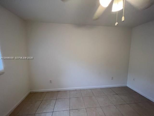Neutral-toned ceramic tile flooring, ceiling fan with integrated light fixture, and horizontal blind window treatment