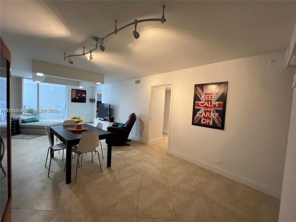 Large-format tile flooring, adjustable track lighting system, and floor-to-ceiling glass paneling