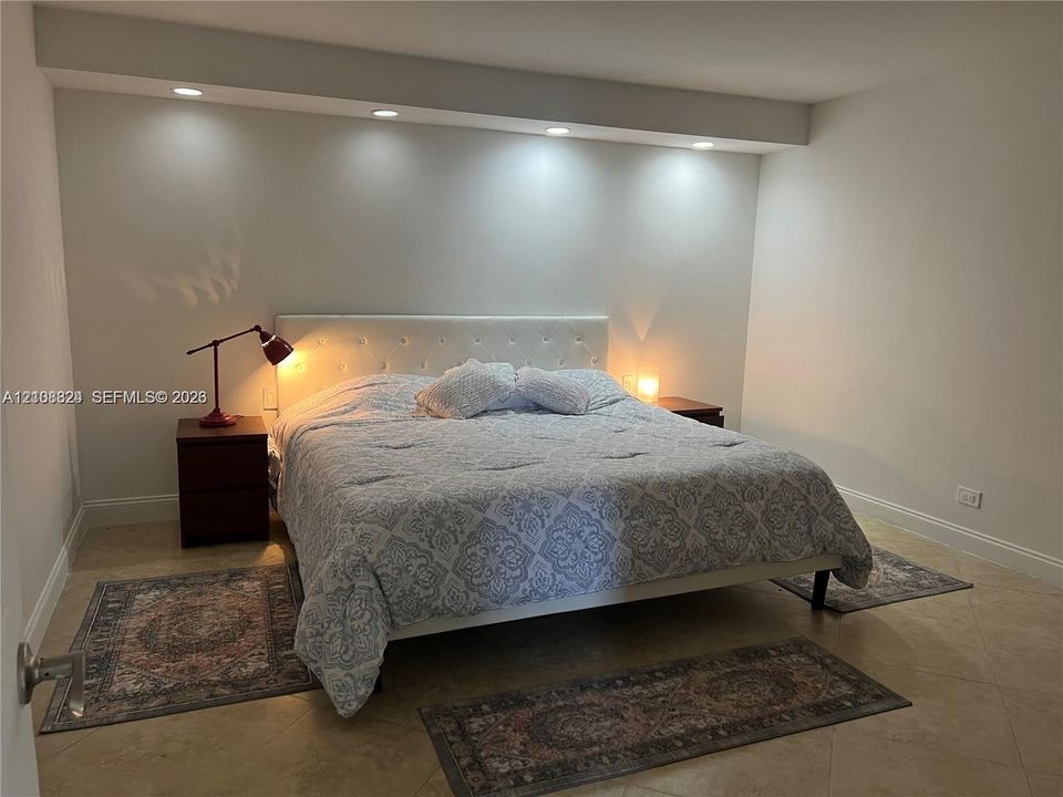 Neutral-toned interior featuring large-format tile flooring and an architectural soffit with recessed downlighting