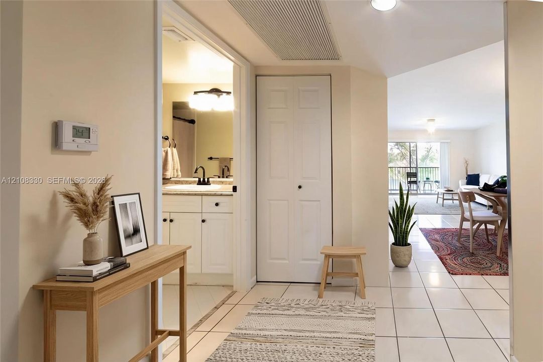 Ceramic tile flooring, white vanity cabinetry with stone-finish countertop, dual-handle faucet, and bi-fold closet doors
