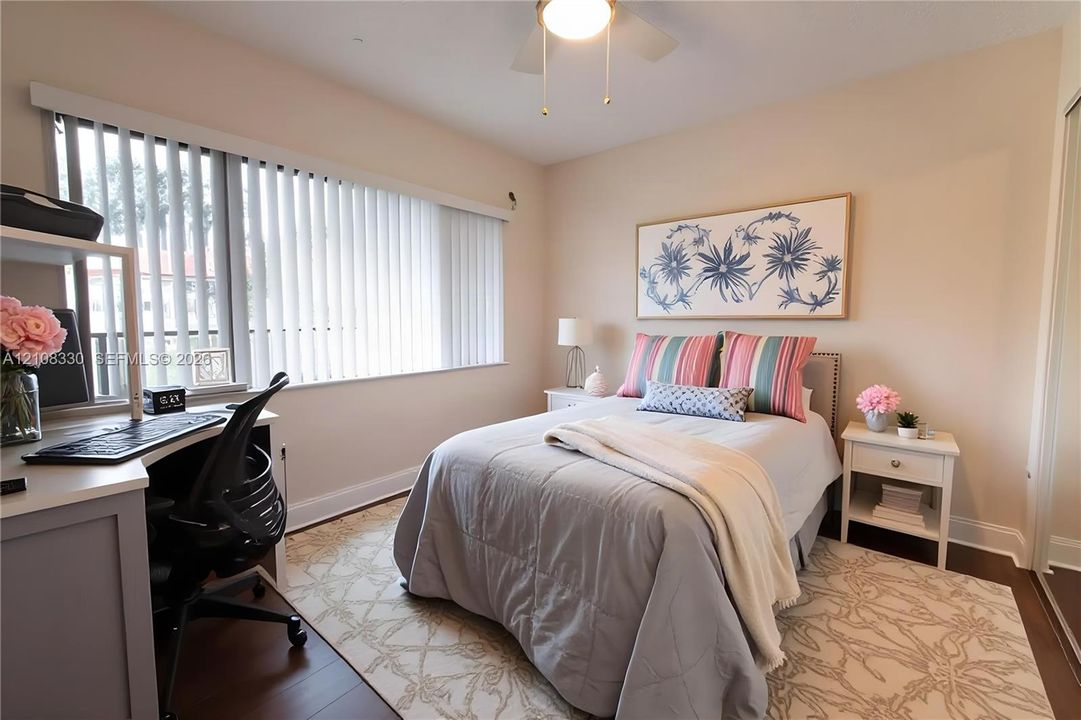 Neutral-toned interior featuring dark wood-finish flooring, vertical slat window blinds, and a ceiling-mounted light fixture with a fan