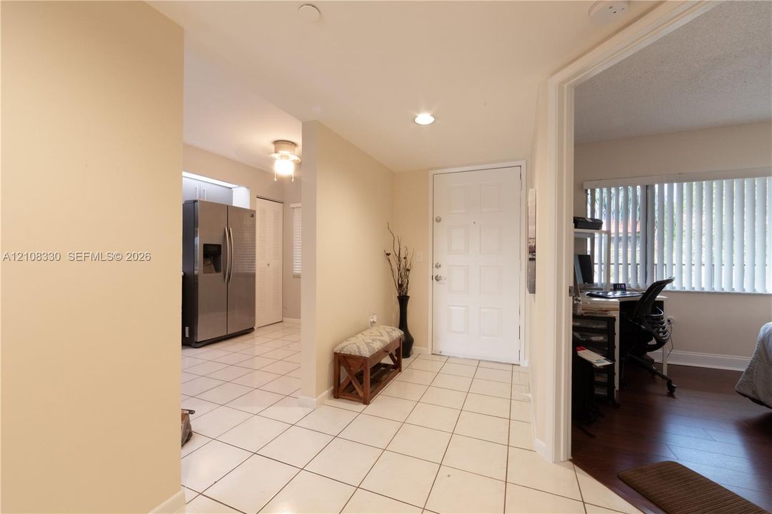 Entryway featuring light-toned ceramic tile flooring, recessed lighting, and a paneled entry door