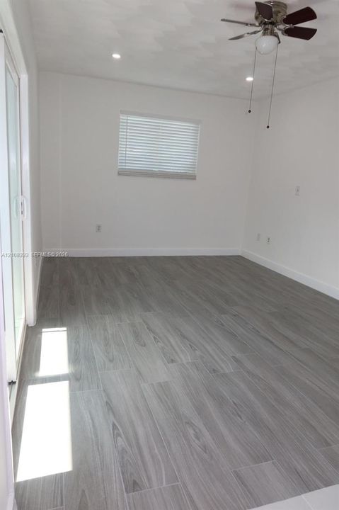 Wood-finish flooring, recessed lighting, ceiling fan with light fixture, and sliding glass door