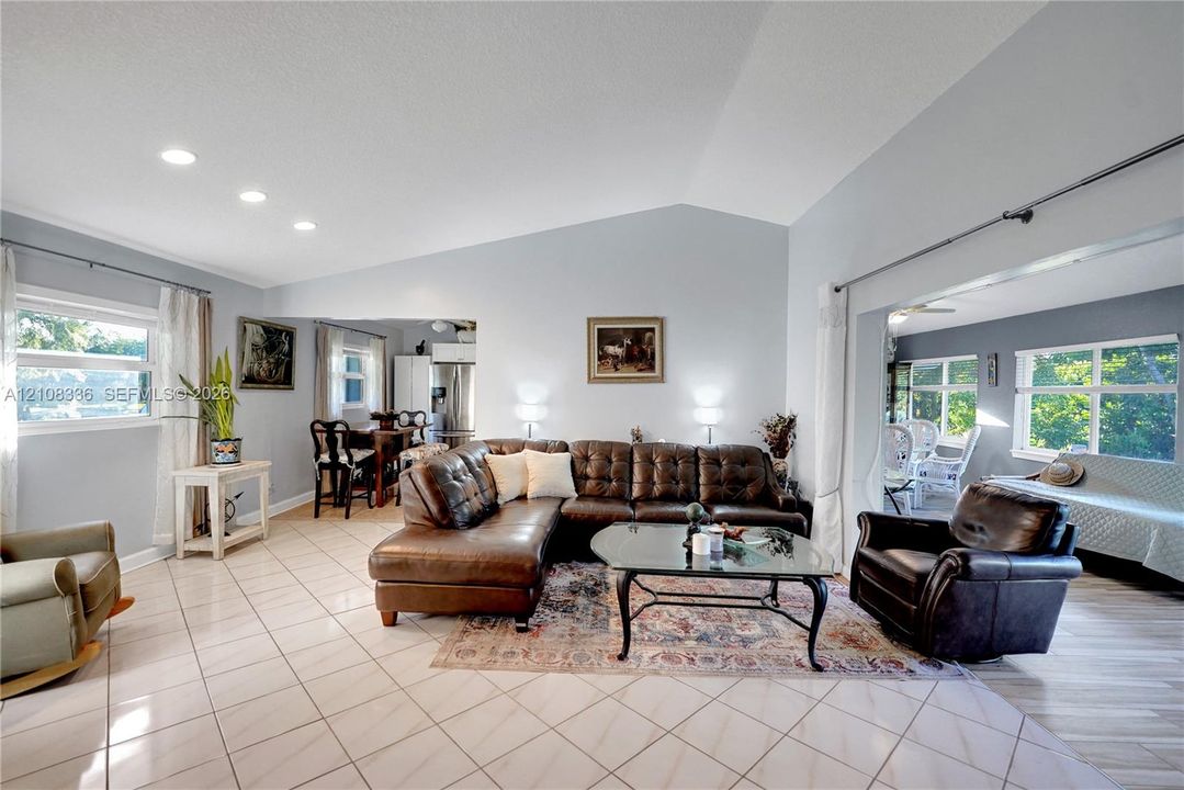 Living area featuring vaulted ceilings, recessed lighting, and ceramic tile flooring